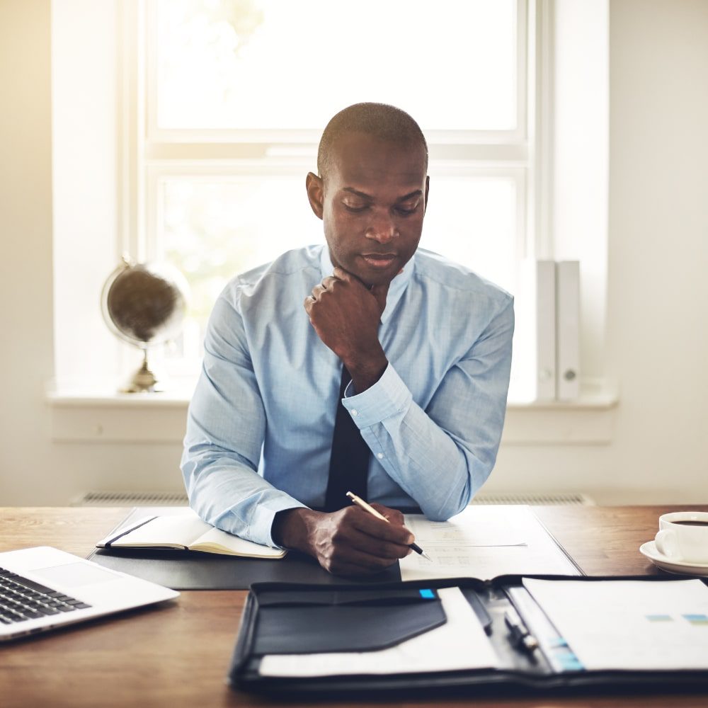 Businessman writing on paper at desk