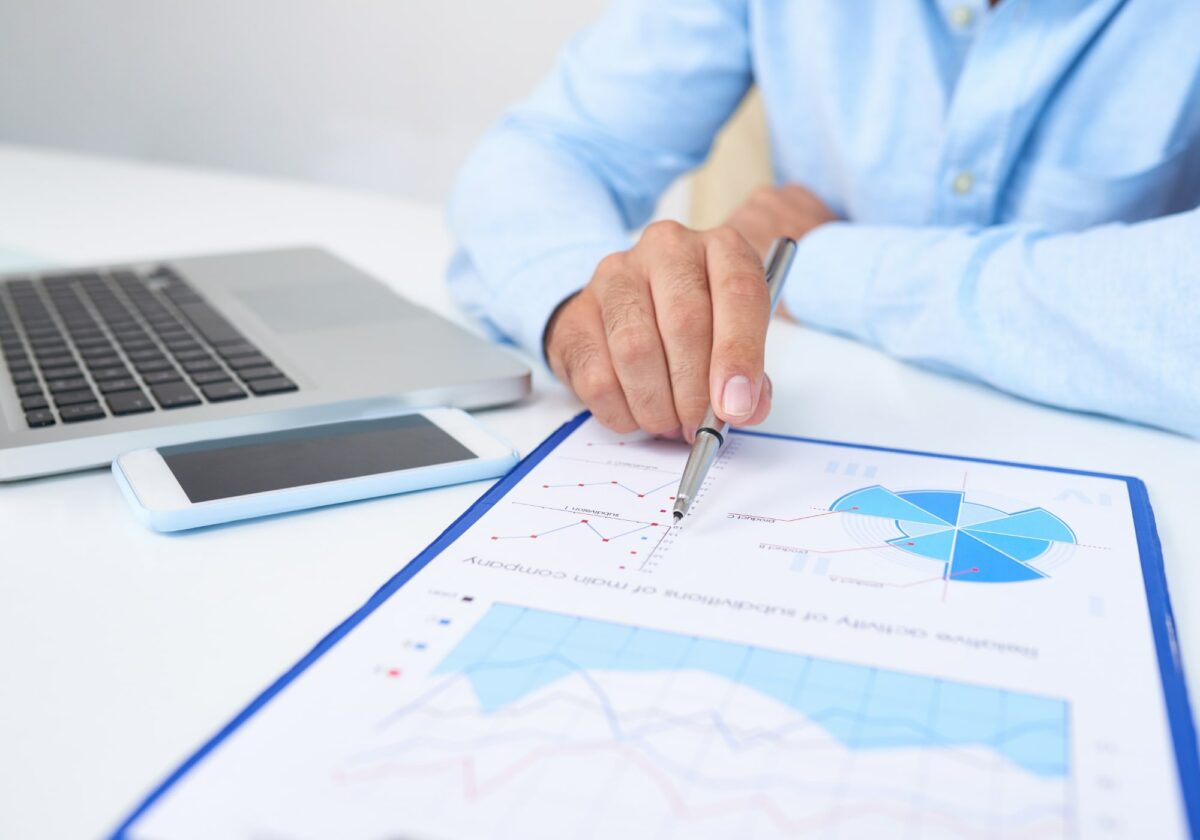 Man at desk in front of document and laptop
