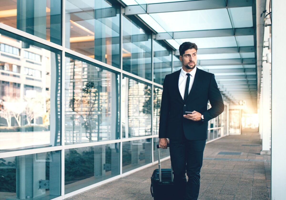 Man in suit walking alongside a building