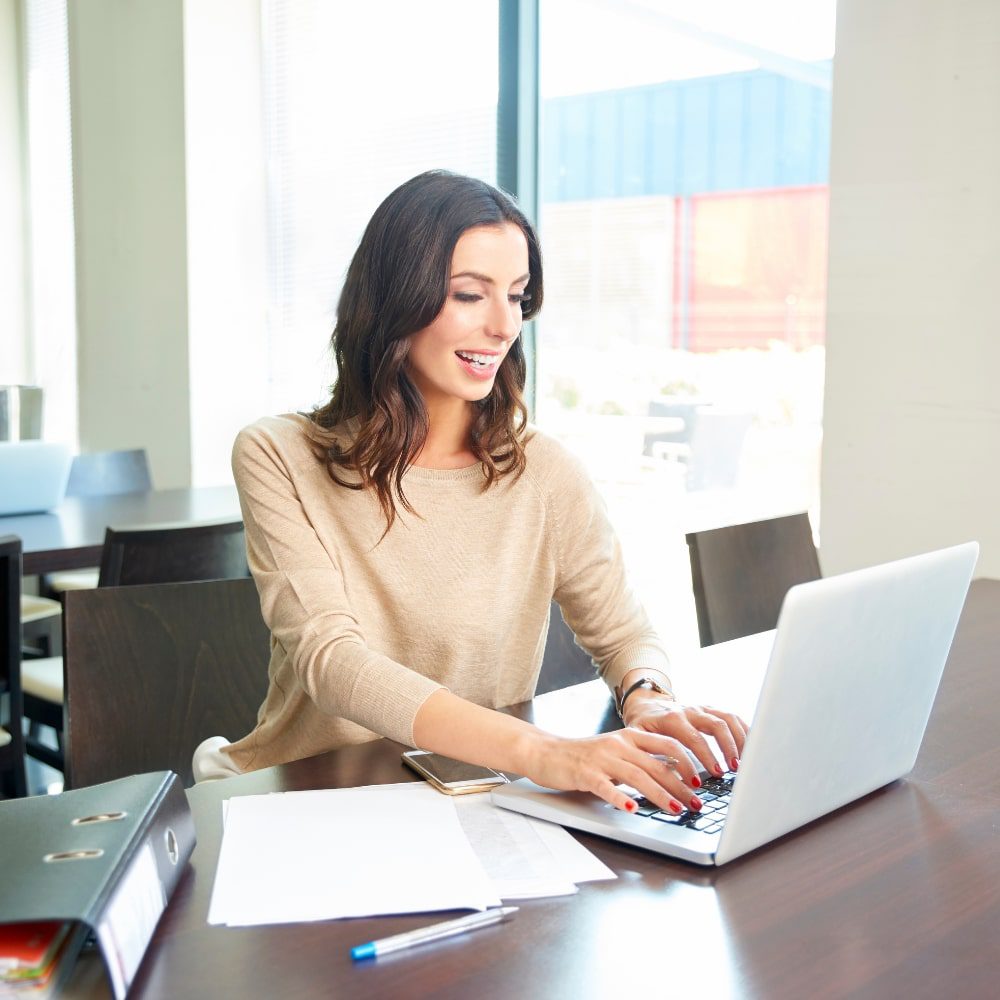 Woman working on a laptop at a table