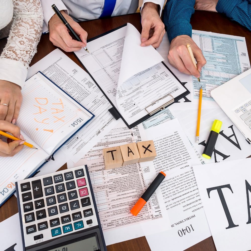 Small group of people filling out lots of tax paperwork