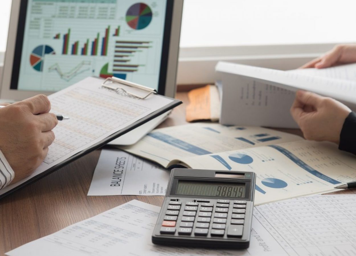 Two people reviewing business documents and charts