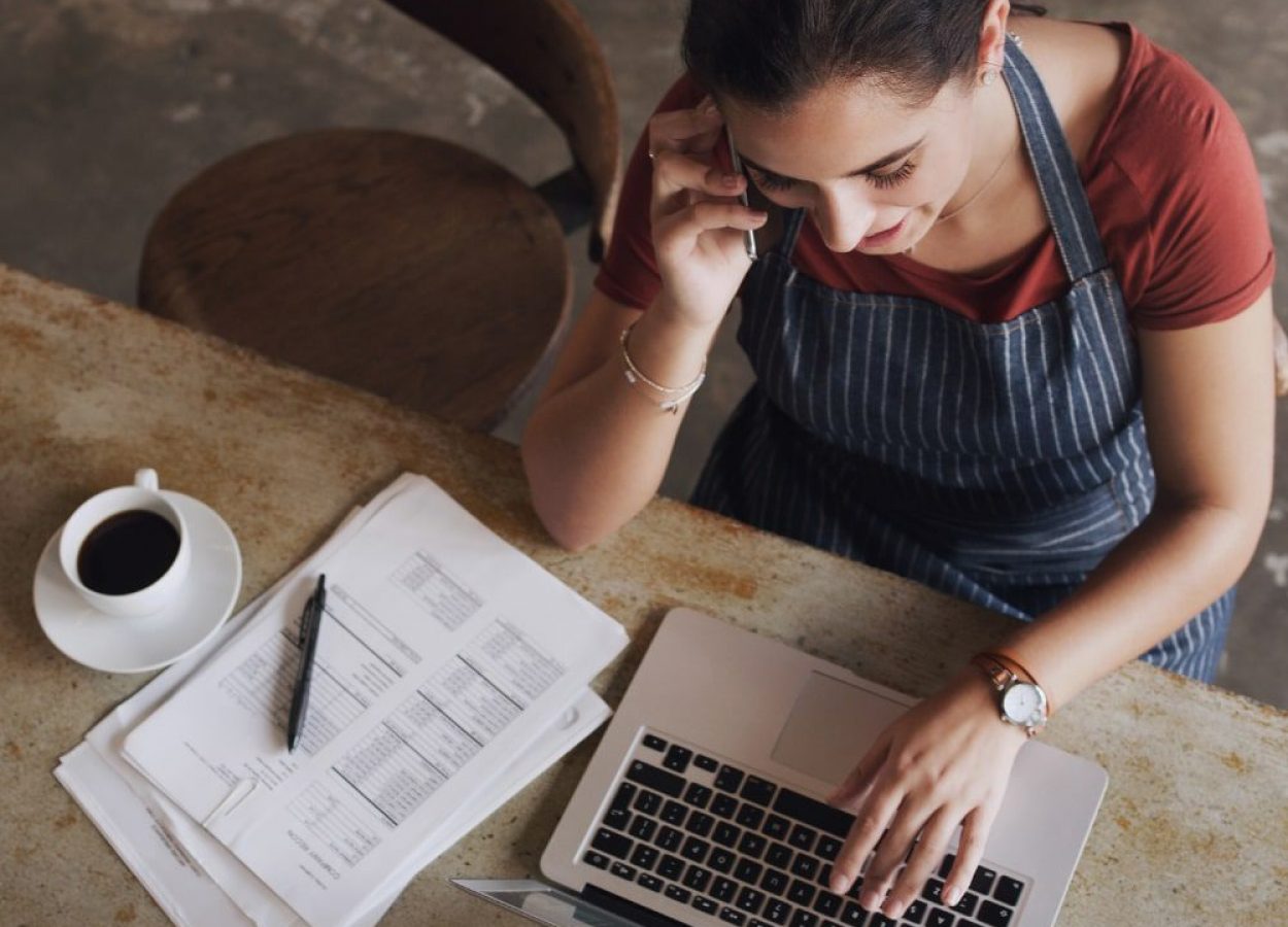 Woman taking a call while working on a laptop