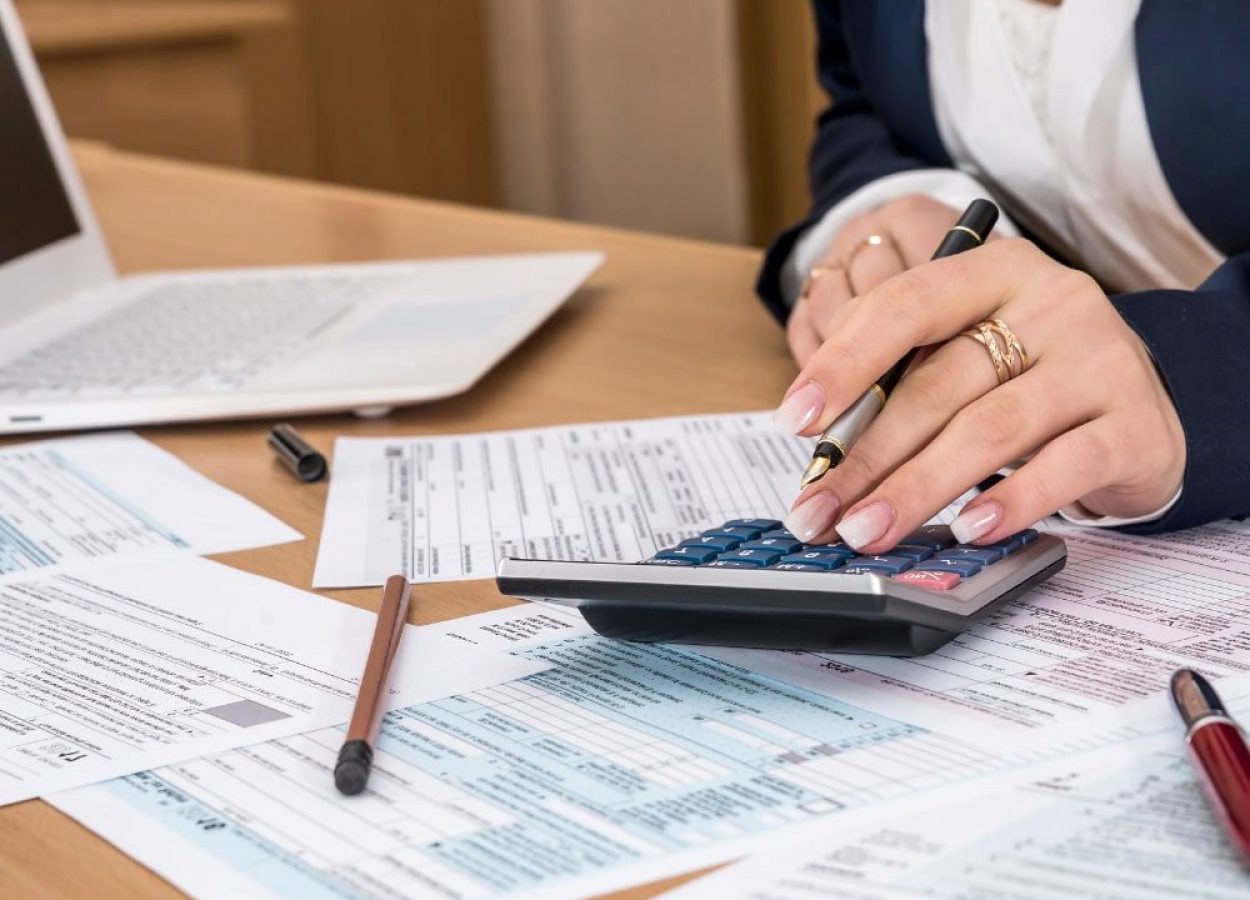 Women uses calculator while filing out tax forms